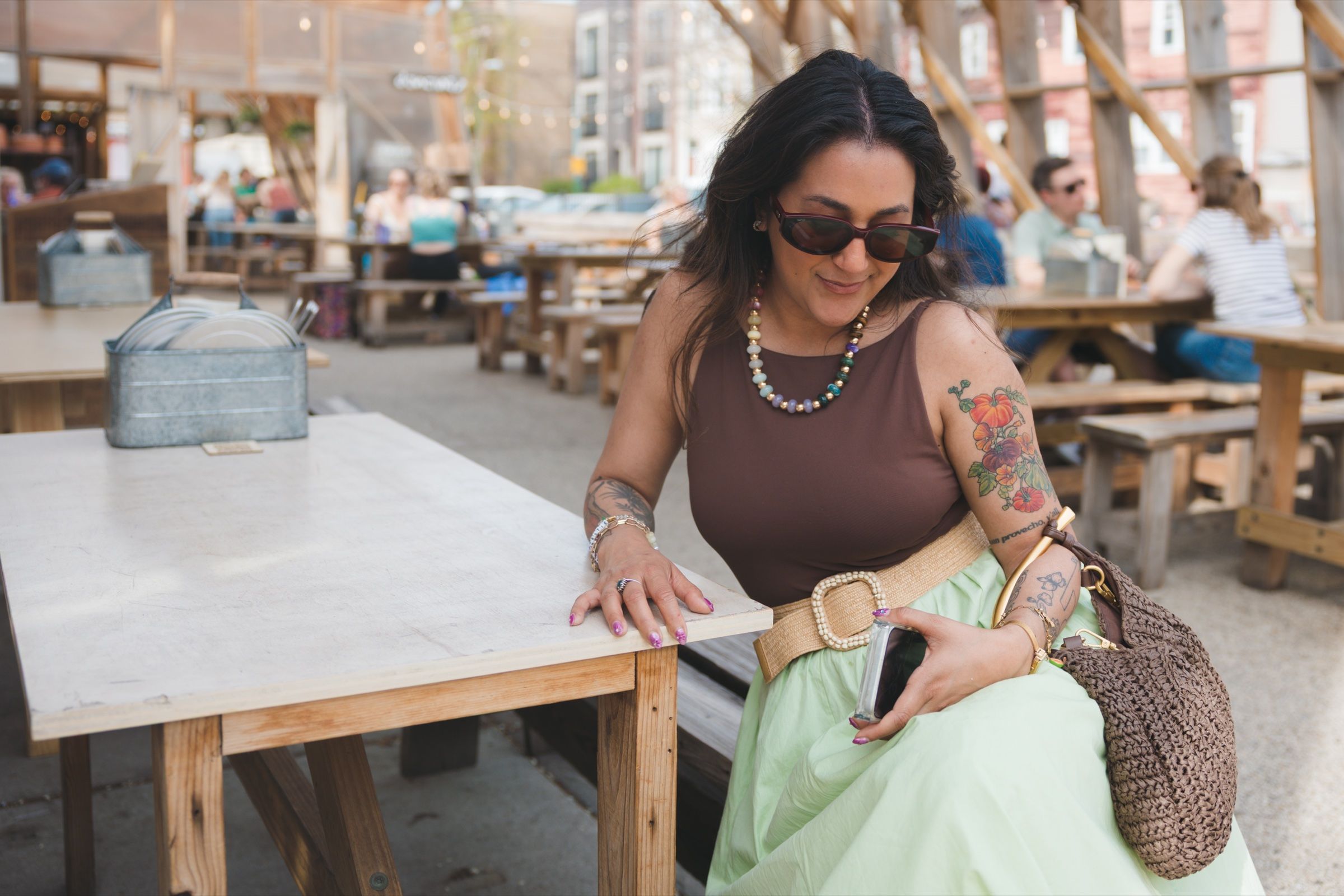 Woman in sunglasses seated at an outdoor restaurant patio