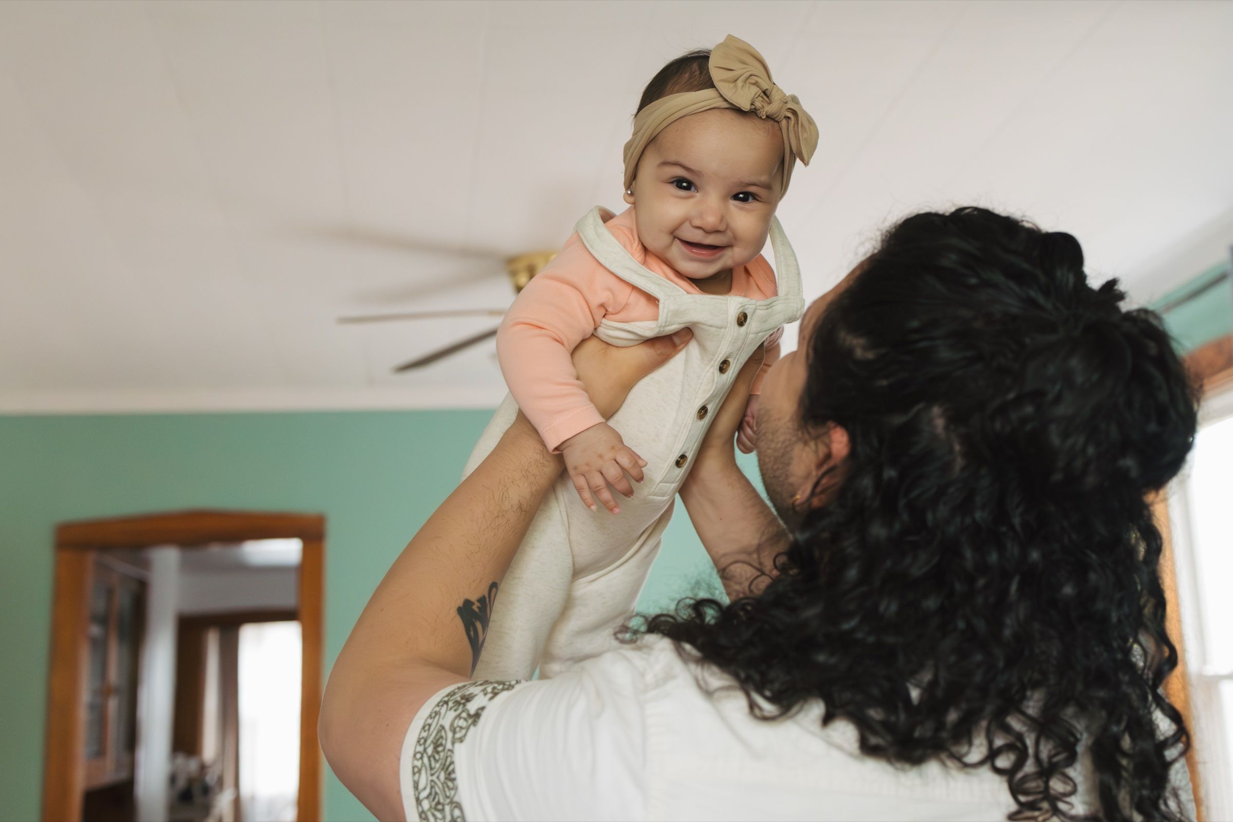 Close portrait of a baby boy in a bow tie held by his mother